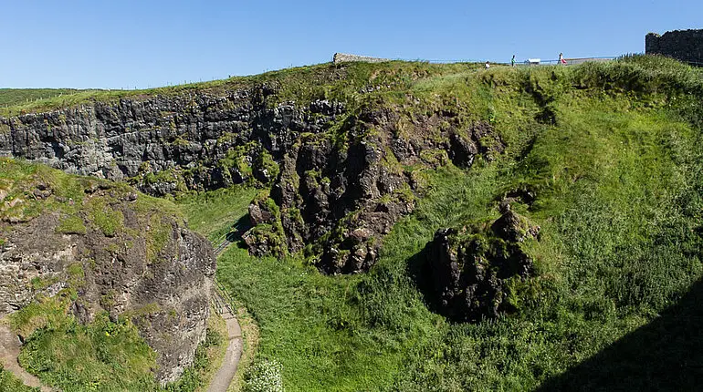ein Spazierweg führt unter das Dunluce Castle