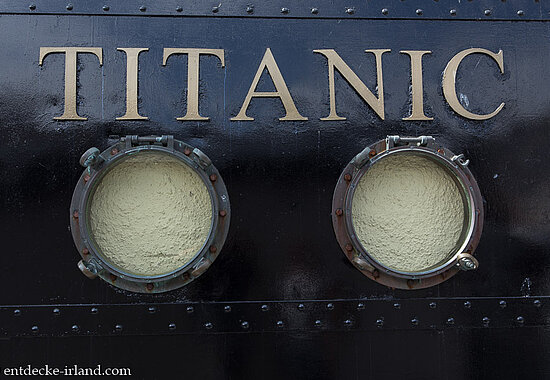 Bullaugen unter dem Titanic-Schriftzug in der Stadt Cobh