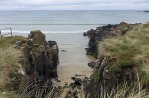 Über die schwarzen Klippen geht es zum goldenen Strand